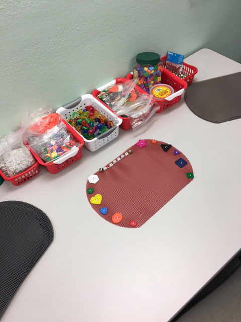 A placemat where tactile objects are attached for children who are Blind